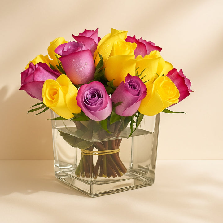 تنسيق أنيق للورود الصفراء والبنفسجية في مزهرية زجاجية مربعة حديثة