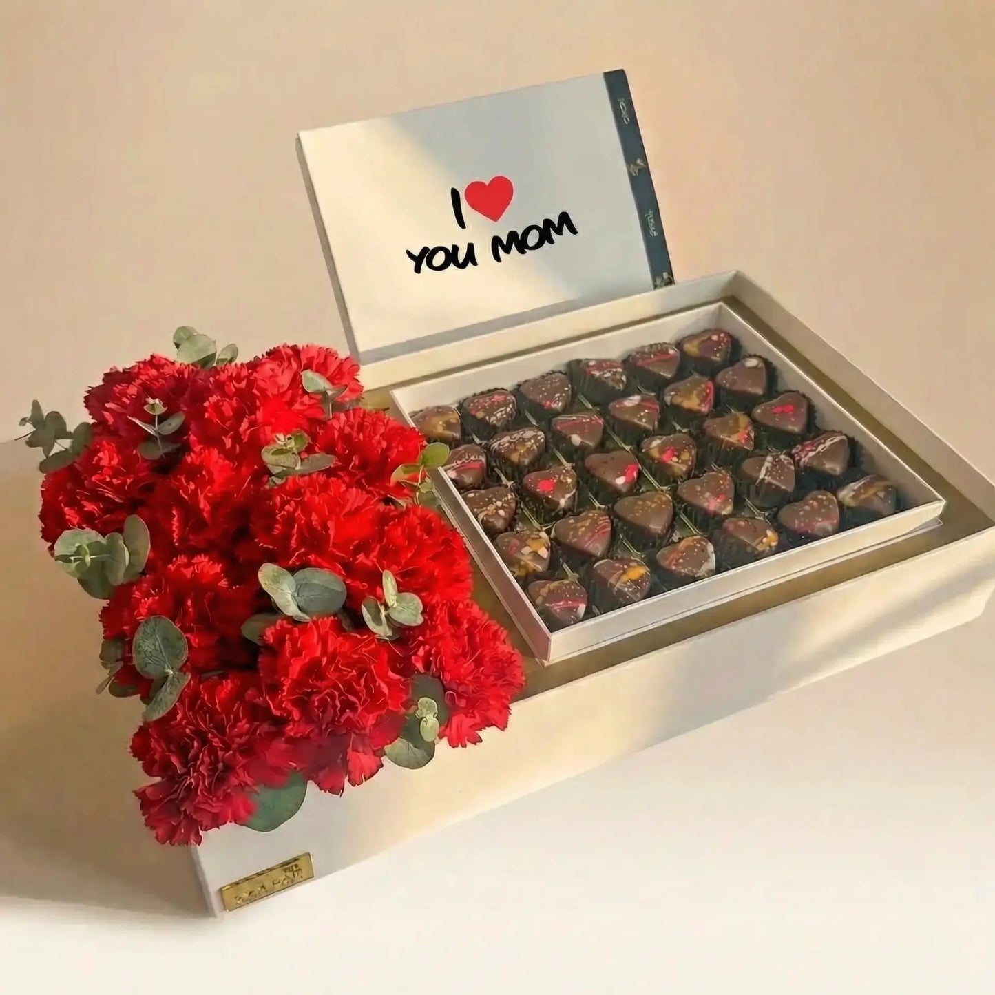 زهور القرنفل الحمراء وصندوق الشوكولاتة الفاخر لعيد الأم