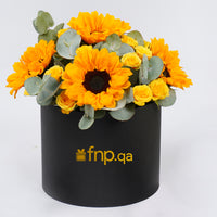 باقة زهور عباد الشمس والورود المشرقة في صندوق أسود أنيق