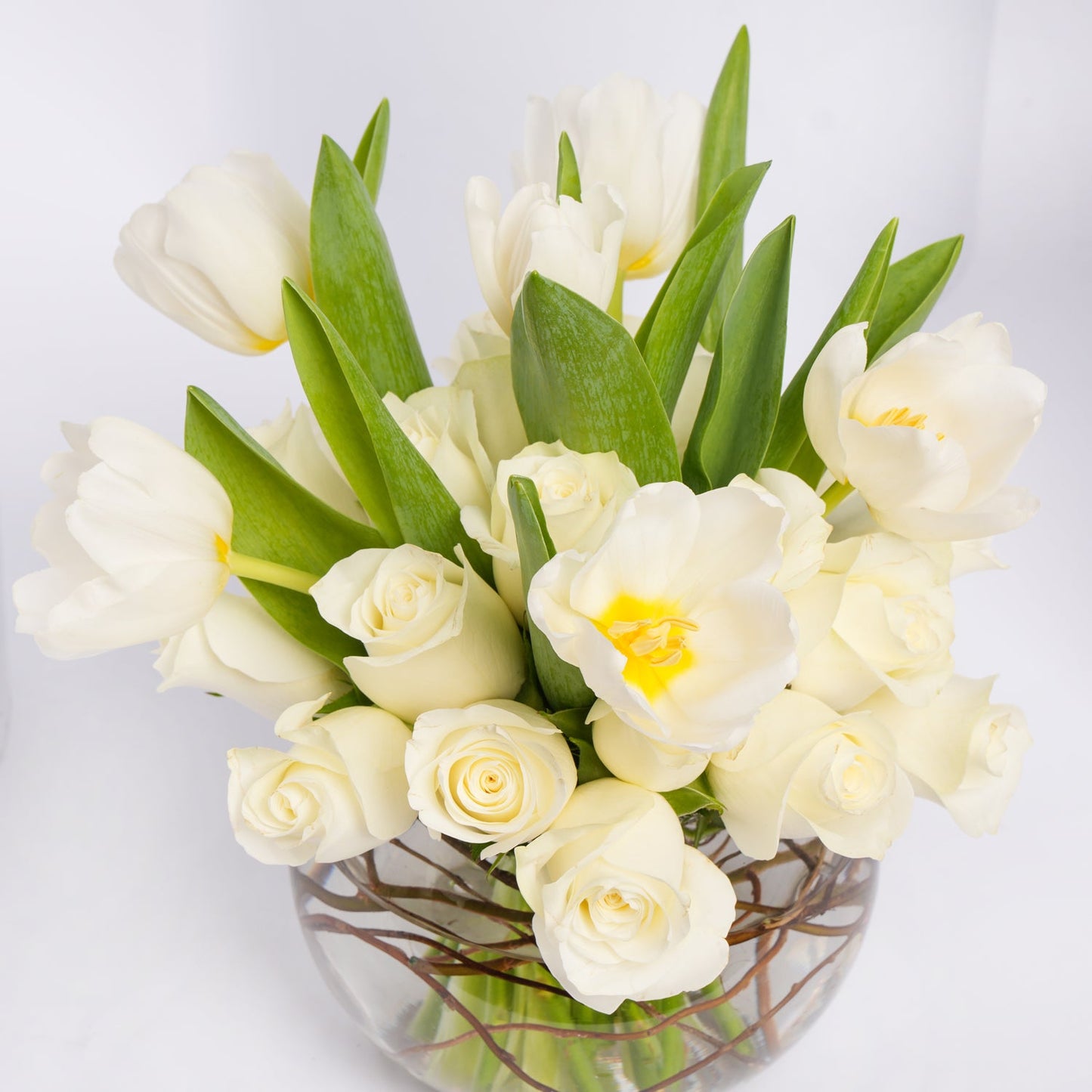 Elegant White Roses and Tulips in a Decorative Glass Vase