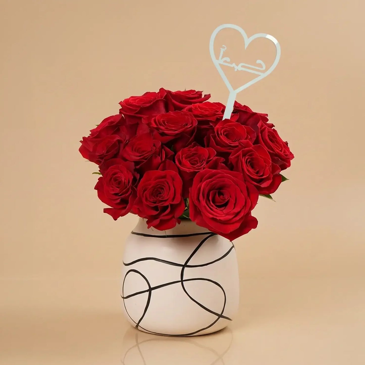 باقة ورد حمراء أنيقة مع مزهرية خزفية ومزينة بحب