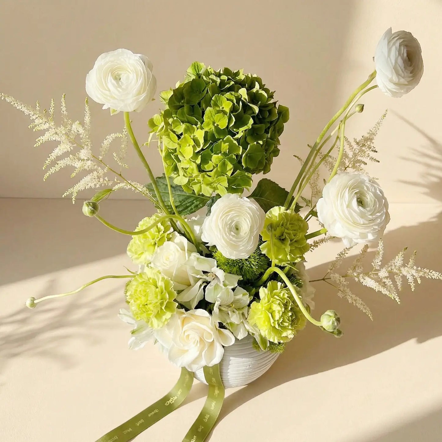 ترتيب زهور نعمة الخضار في مزهرية بيضاء أنيقة