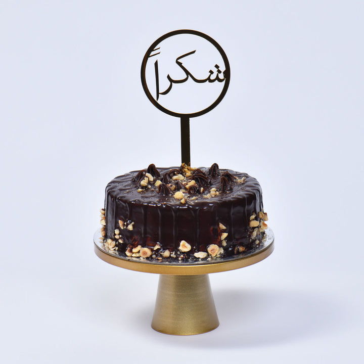 باقة ورود قرمزية أنيقة مع كعكة بالشوكولاتة والبندق