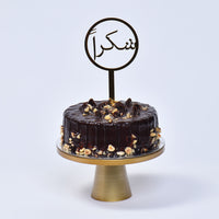 باقة ورود قرمزية أنيقة مع كعكة بالشوكولاتة والبندق