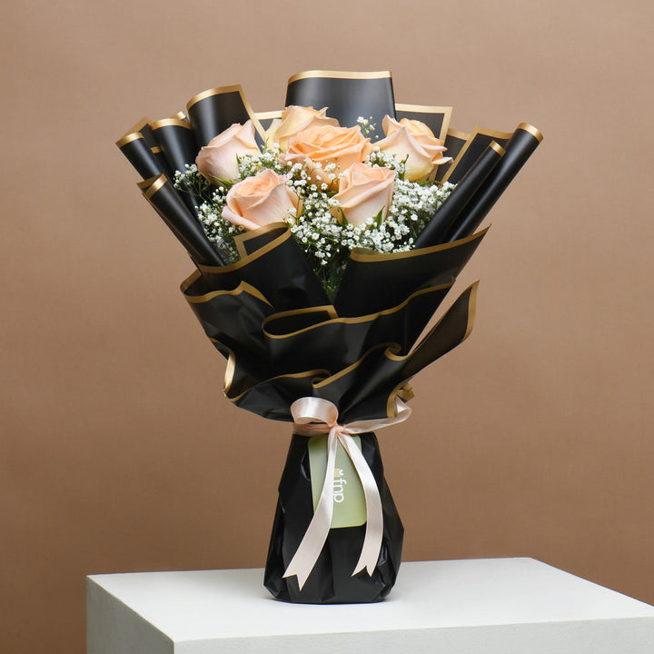 باقة ورد خوخي أنيقة مع كعكة بلاك فورست شهية