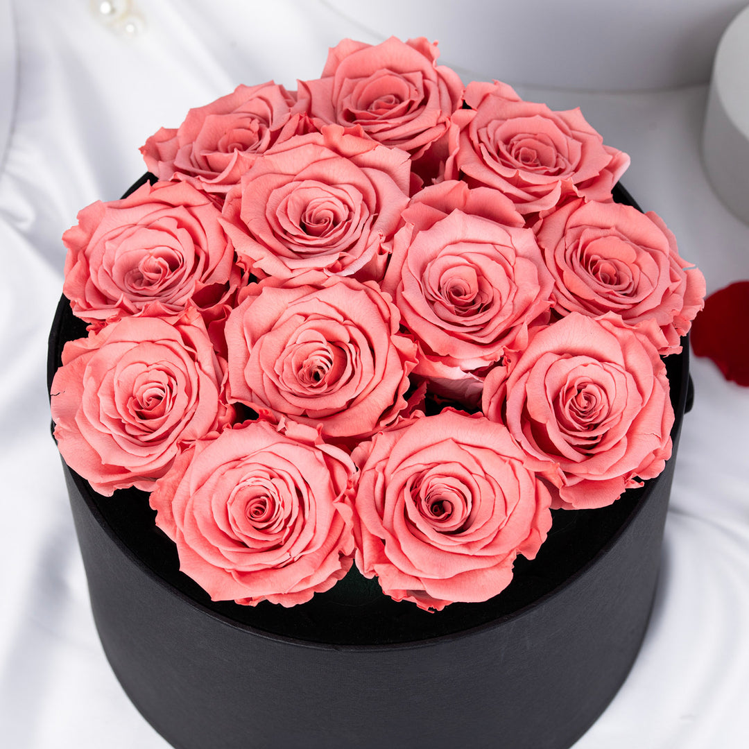 أزهار من القلب – 12 وردة وردية أبدية فاخرة في علبة سوداء أنيقة