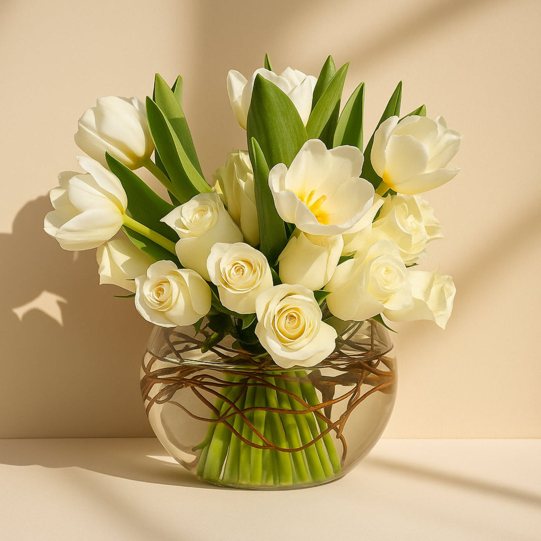 باقة من الورود البيضاء والأزهار في مزهرية زجاجية أنيقة