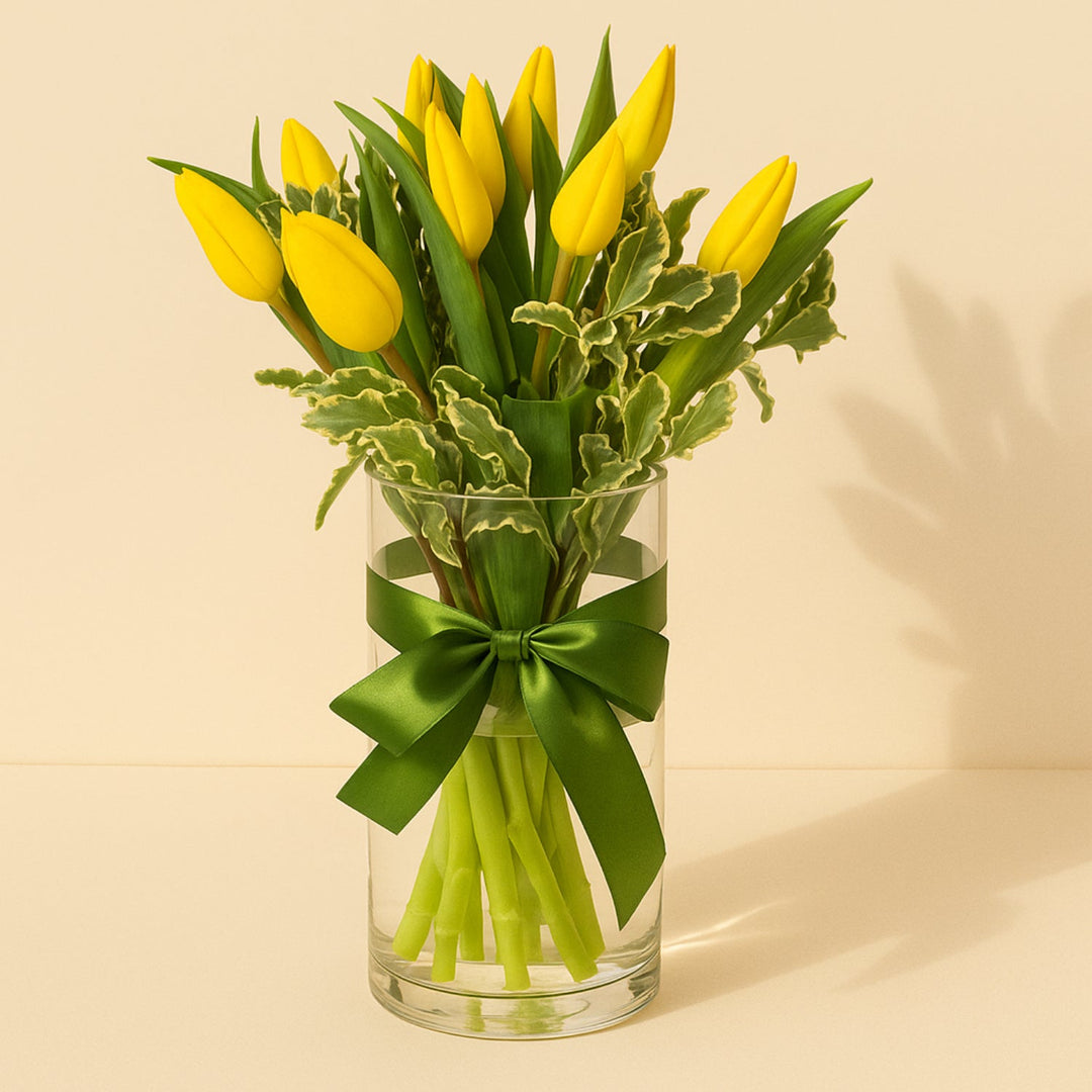 باقة زهور التوليب الصفراء الأنيقة في مزهرية زجاجية مع شريط