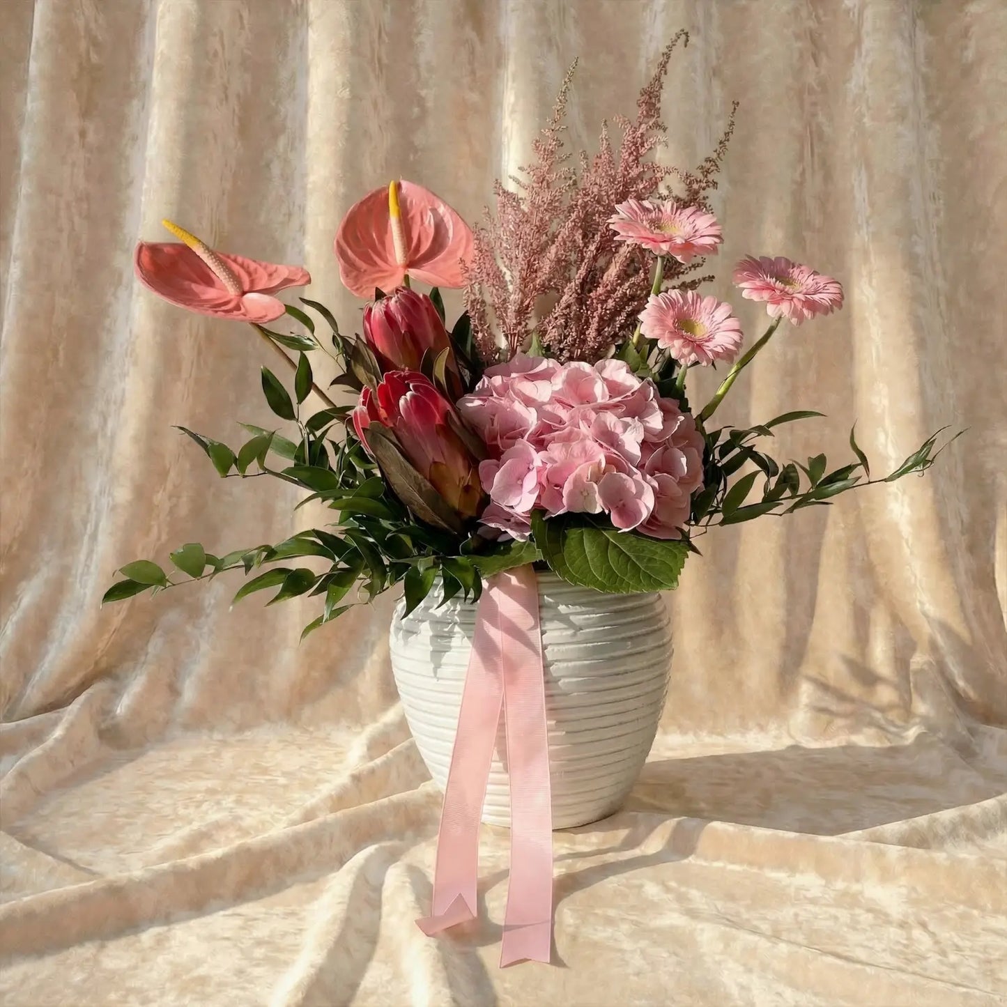 باقة الأنتوريوم والجيربيرا الوردية الأنيقة في وعاء أبيض