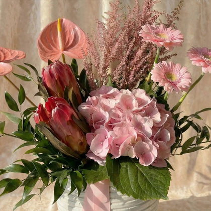 باقة الأنتوريوم والجيربيرا الوردية الأنيقة في وعاء أبيض