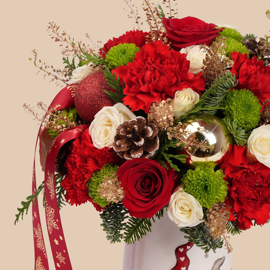 ترتيب زهور عيد الميلاد في إبريق زخرفي