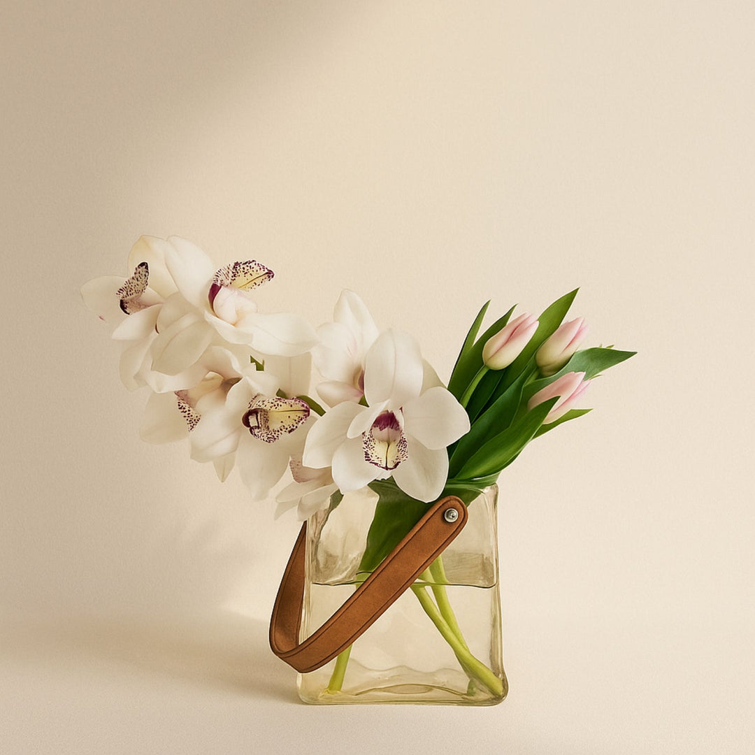 ترتيب زهور أنيق: سيمبيديوم أبيض وتوليب وردي في مزهرية زجاجية أنيقة