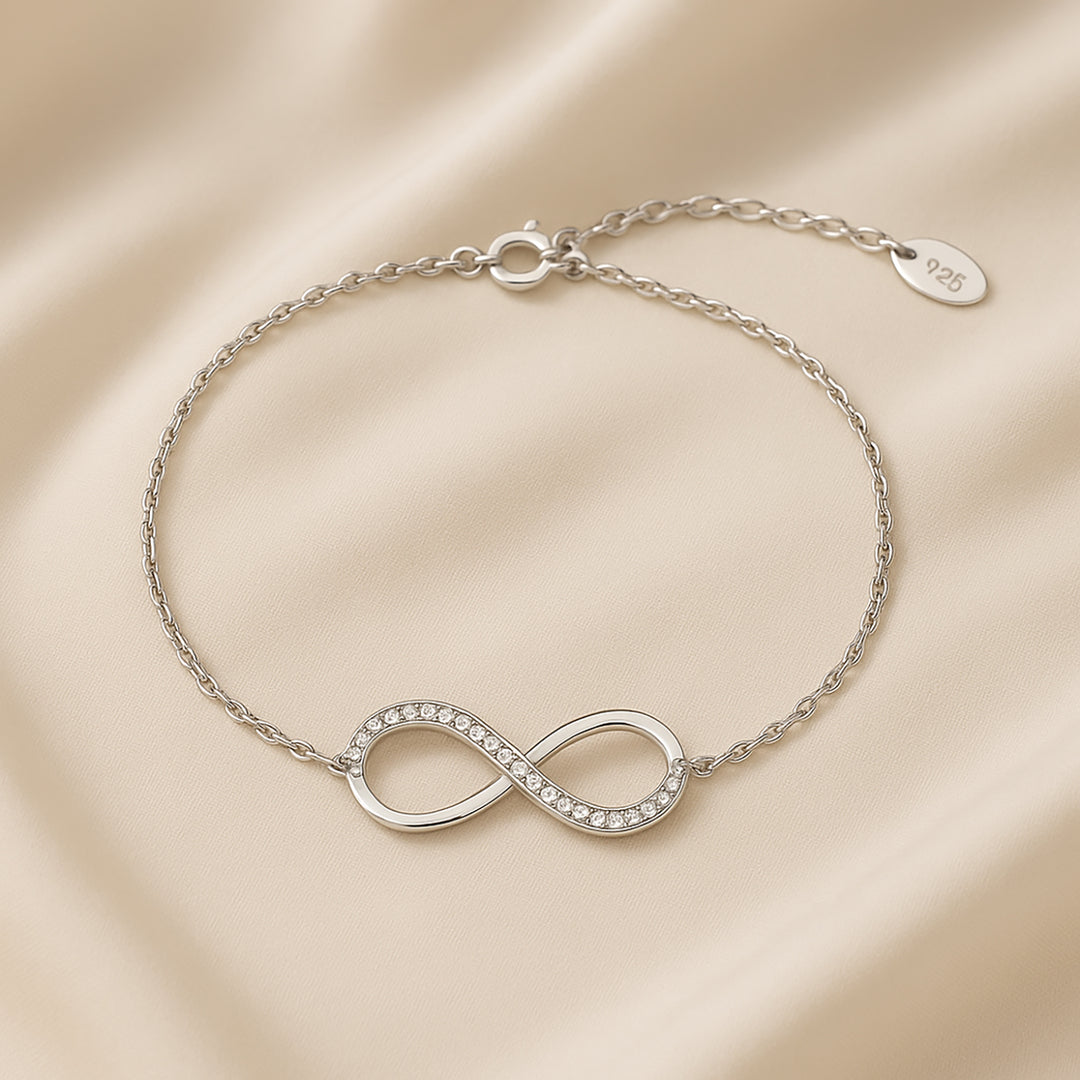 سوار فضي أنيق بتصميم لانهائي مع ورود وردية تحت قبة زجاجية