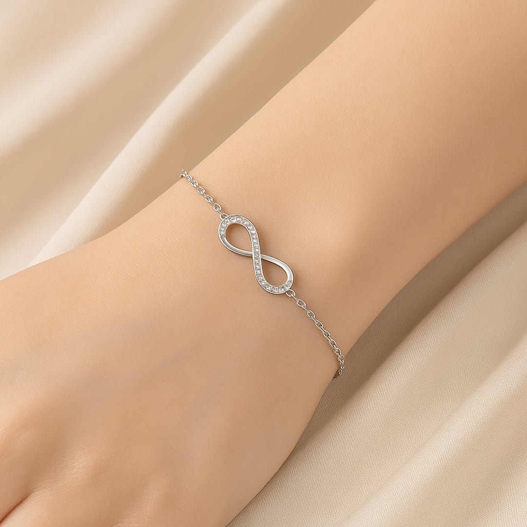 سوار فضي أنيق بتصميم لانهائي مع ورود وردية تحت قبة زجاجية