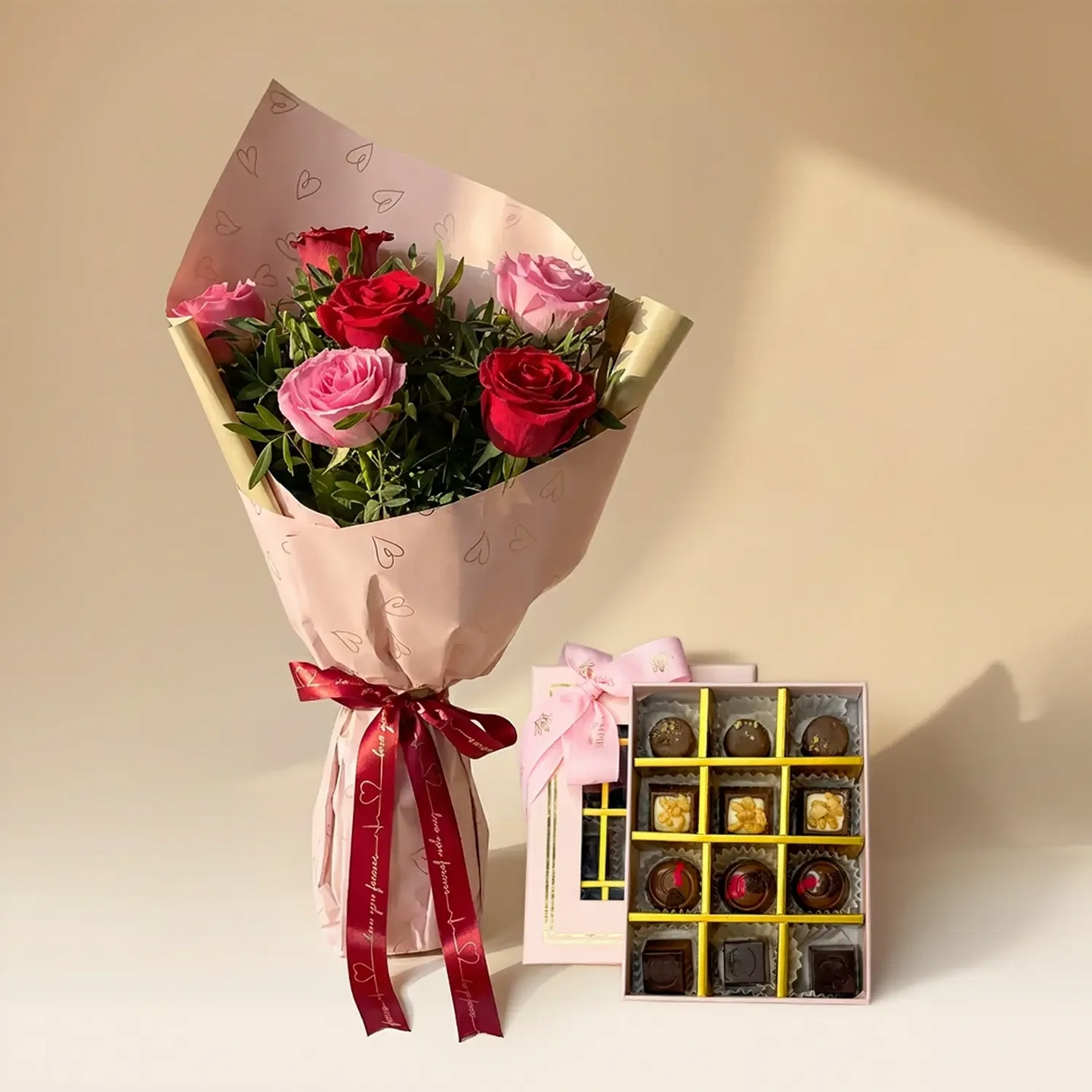 باقة ورود وردية وحمراء أنيقة مع شوكولاتة متنوعة