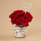باقة ورد حمراء أنيقة مع مزهرية خزفية ومزينة بحب