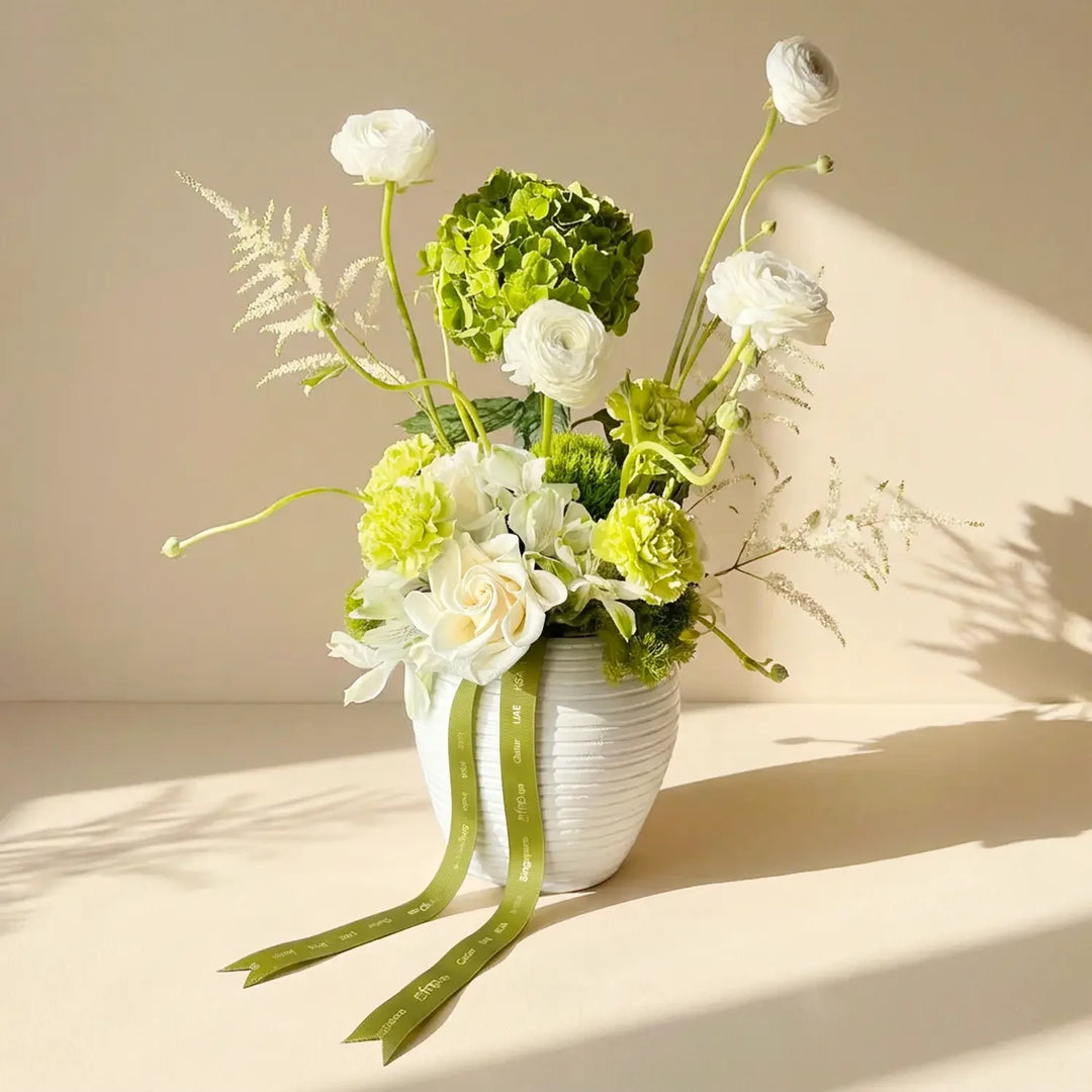 ترتيب زهور نعمة الخضار في مزهرية بيضاء أنيقة