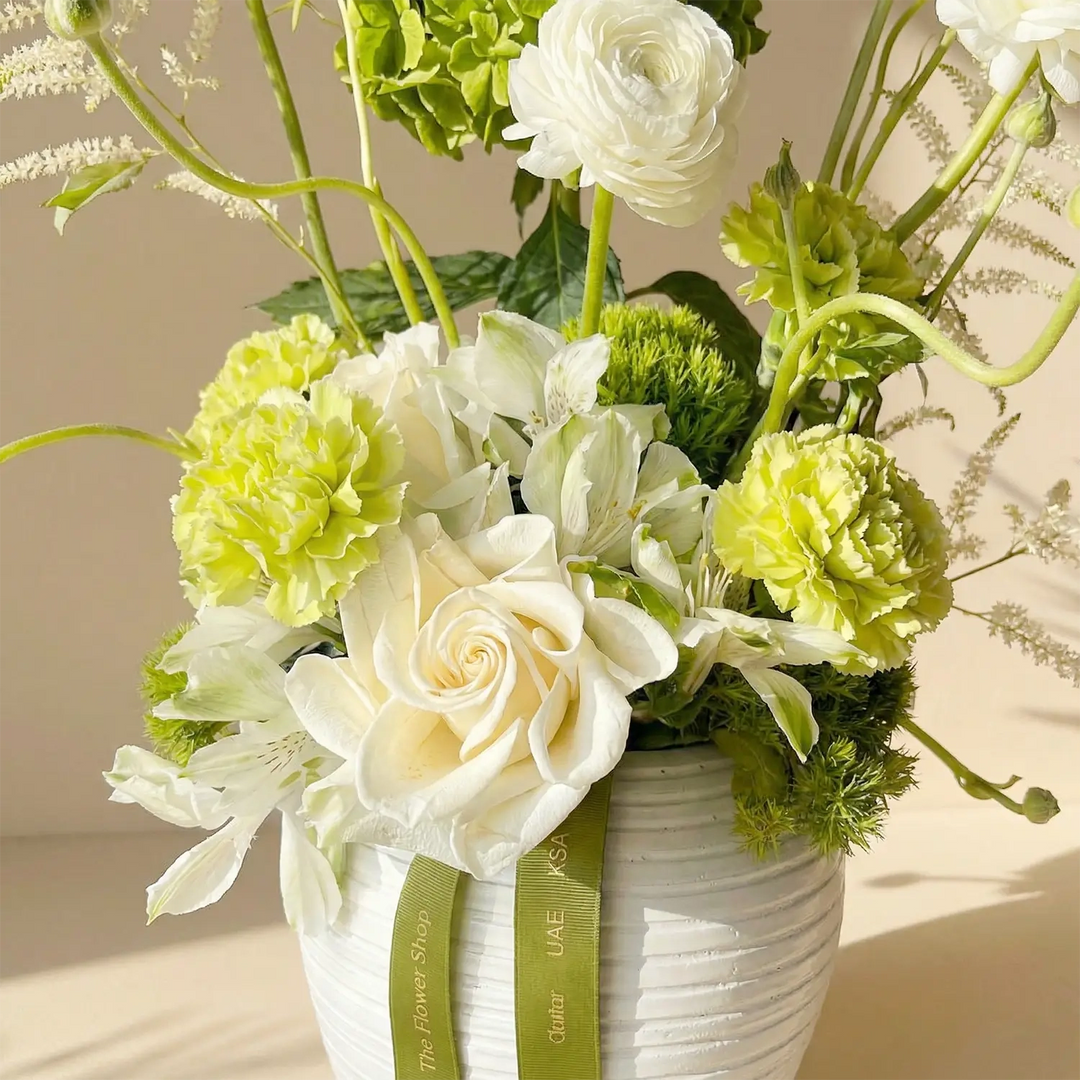 ترتيب زهور نعمة الخضار في مزهرية بيضاء أنيقة