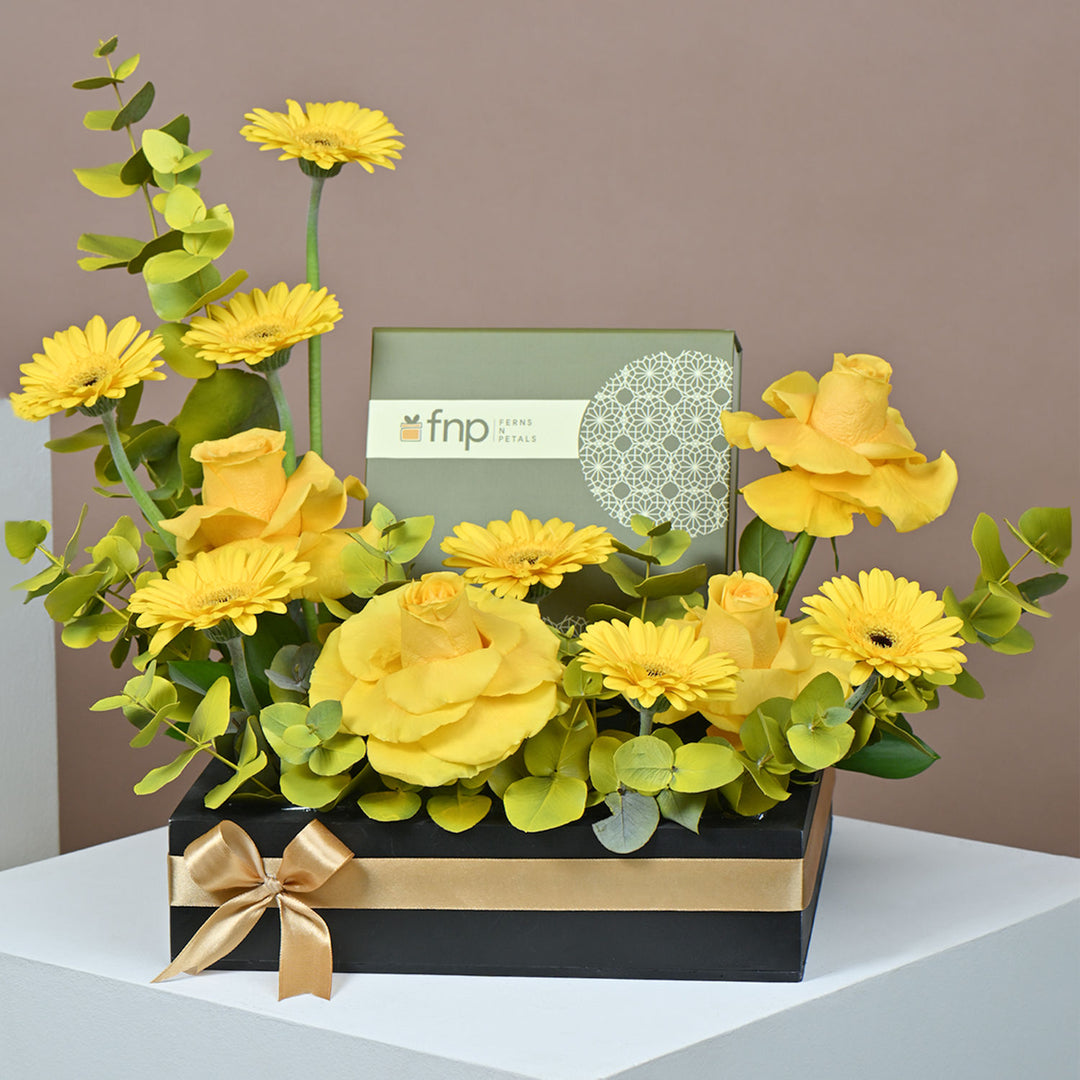 تنسيق زهور صفراء أنيق مع شوكولاتة فاخرة