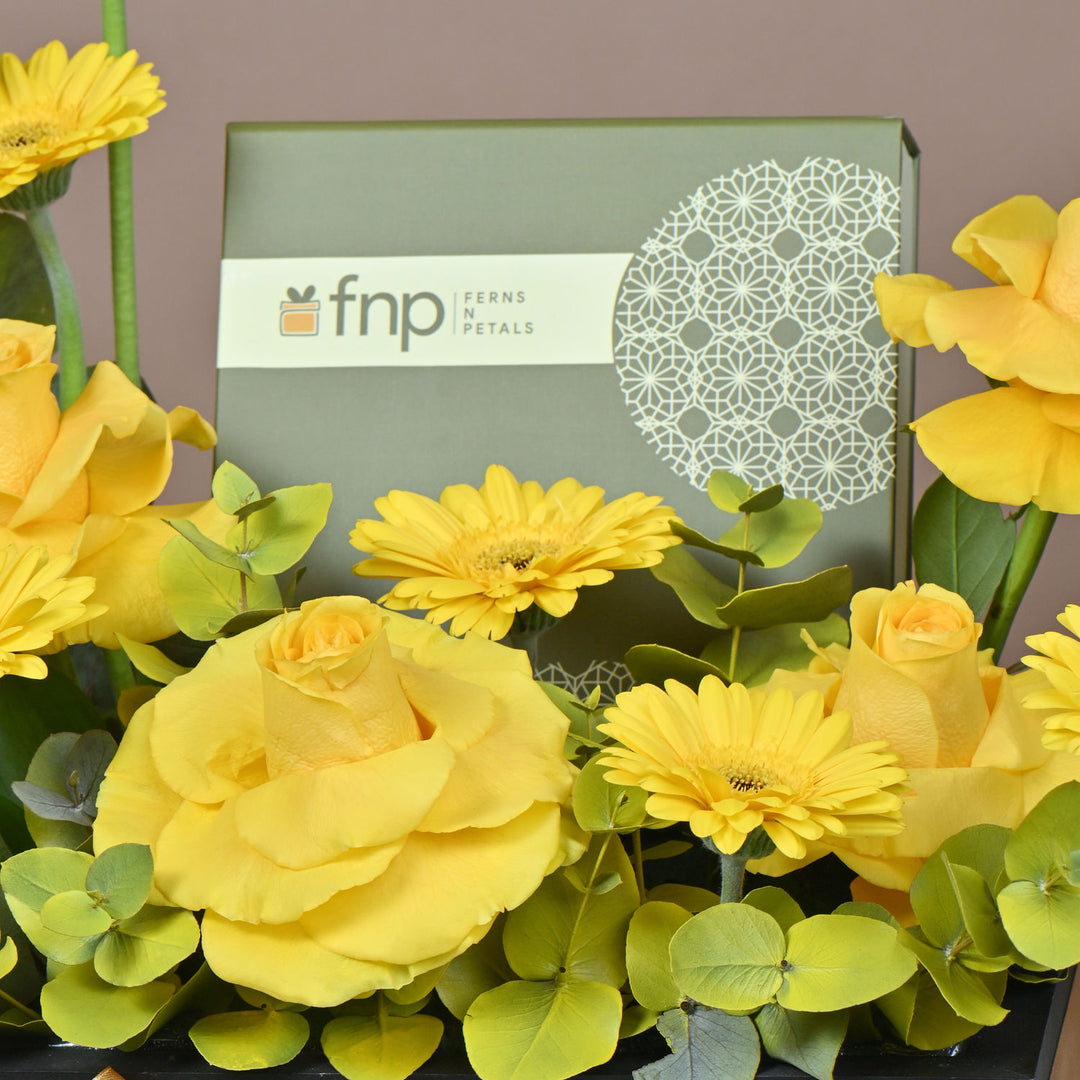 تنسيق زهور صفراء أنيق مع شوكولاتة فاخرة