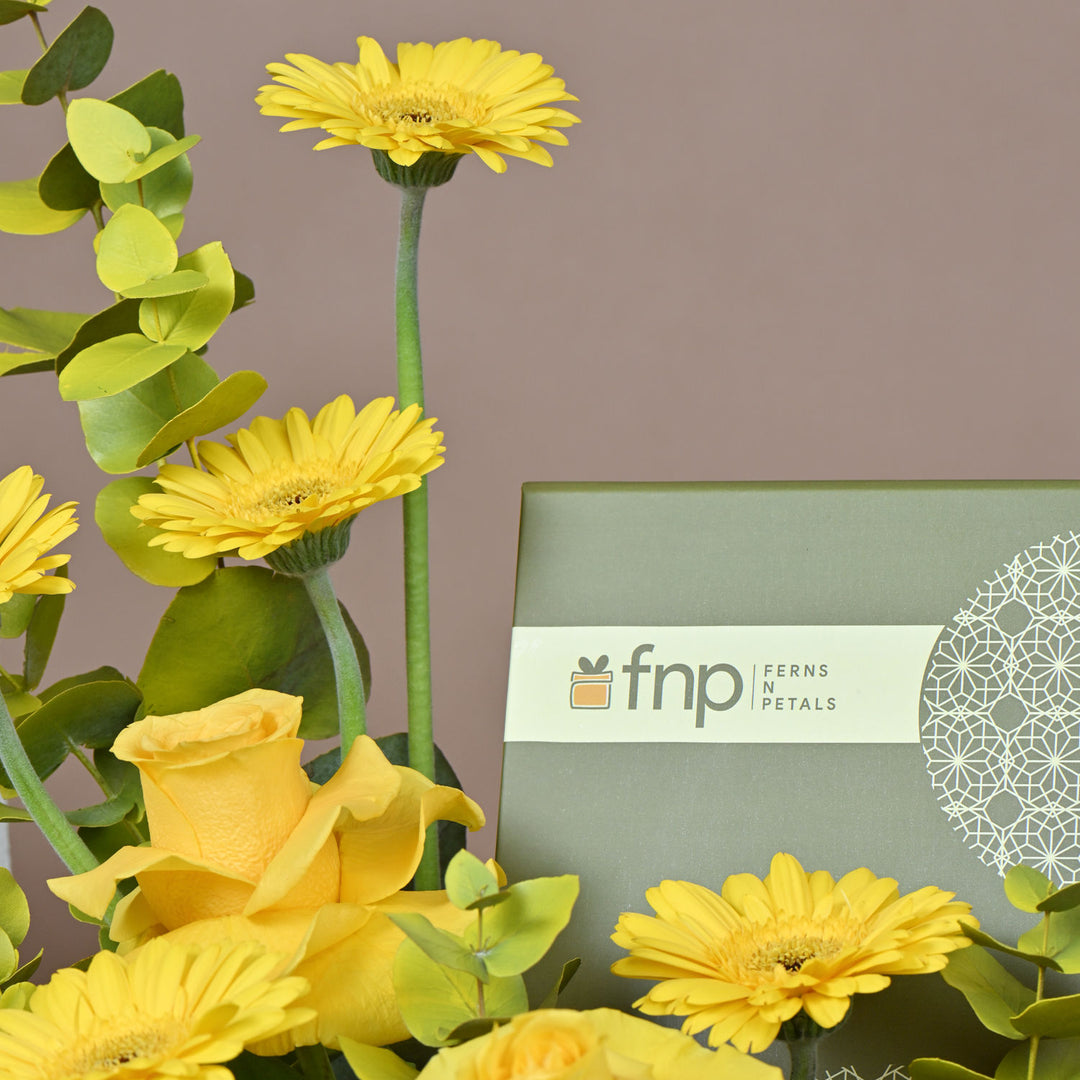 تنسيق زهور صفراء أنيق مع شوكولاتة فاخرة