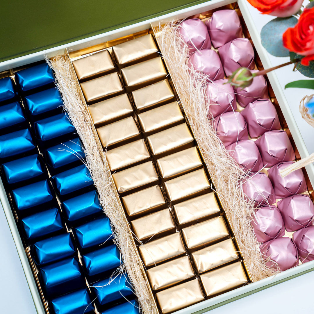 تنسيق زهور أنيق مع علبة شوكولاتة فاخرة