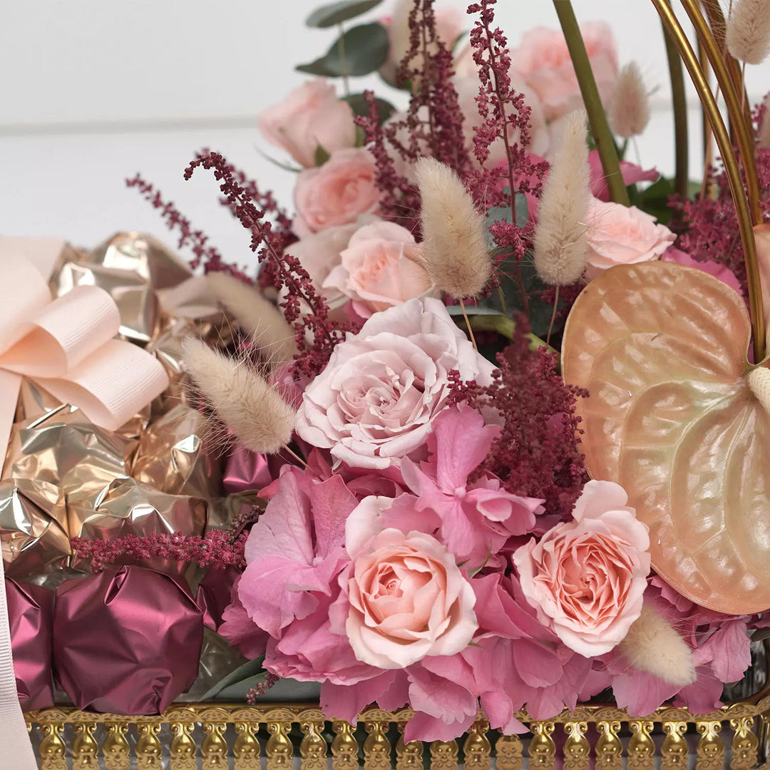 زهور متنوعة وشوكولاتة فاخرة في قفص زخرفي