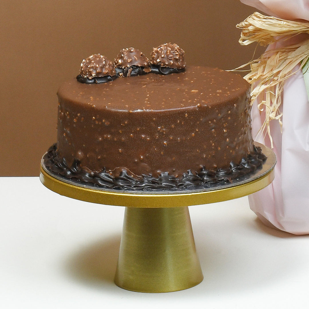 رومانسية لا تُنسى: ورود حمراء وزهرية مع كعكة فيريرو روشيه بالشوكولاتة